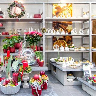 Herbstlich-weihnachtliche Dekoration im Verkaufsraum mit Kranz und Gestecken