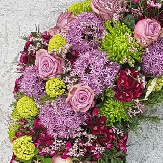 Trauerkranz mit rosafarbenen Rosen und grünen Chrysanthemen